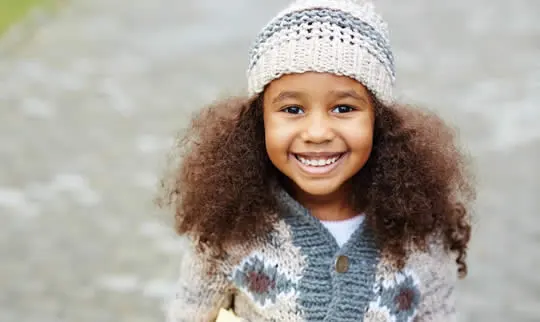 Smiling child wearing a hat after an orthodontic check